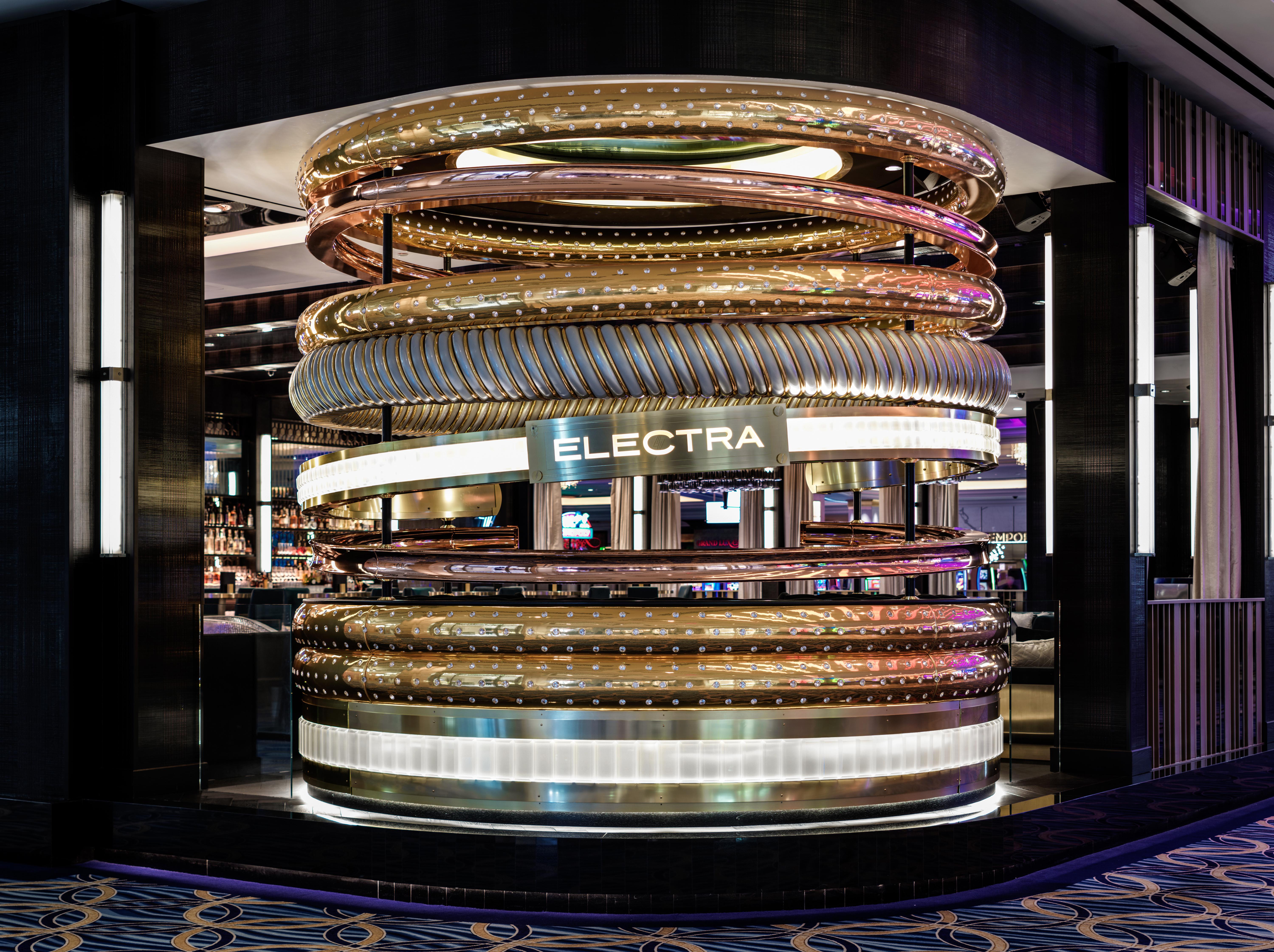 The Palazzo At The Venetian Hotel Las Vegas Exterior photo The photo shows a stylish and modern bar or lounge area with a prominent circular structure that features multiple intertwined rings. This structure is designed with a mix of metallic elements, including gold and silver tones, which creates a visuall