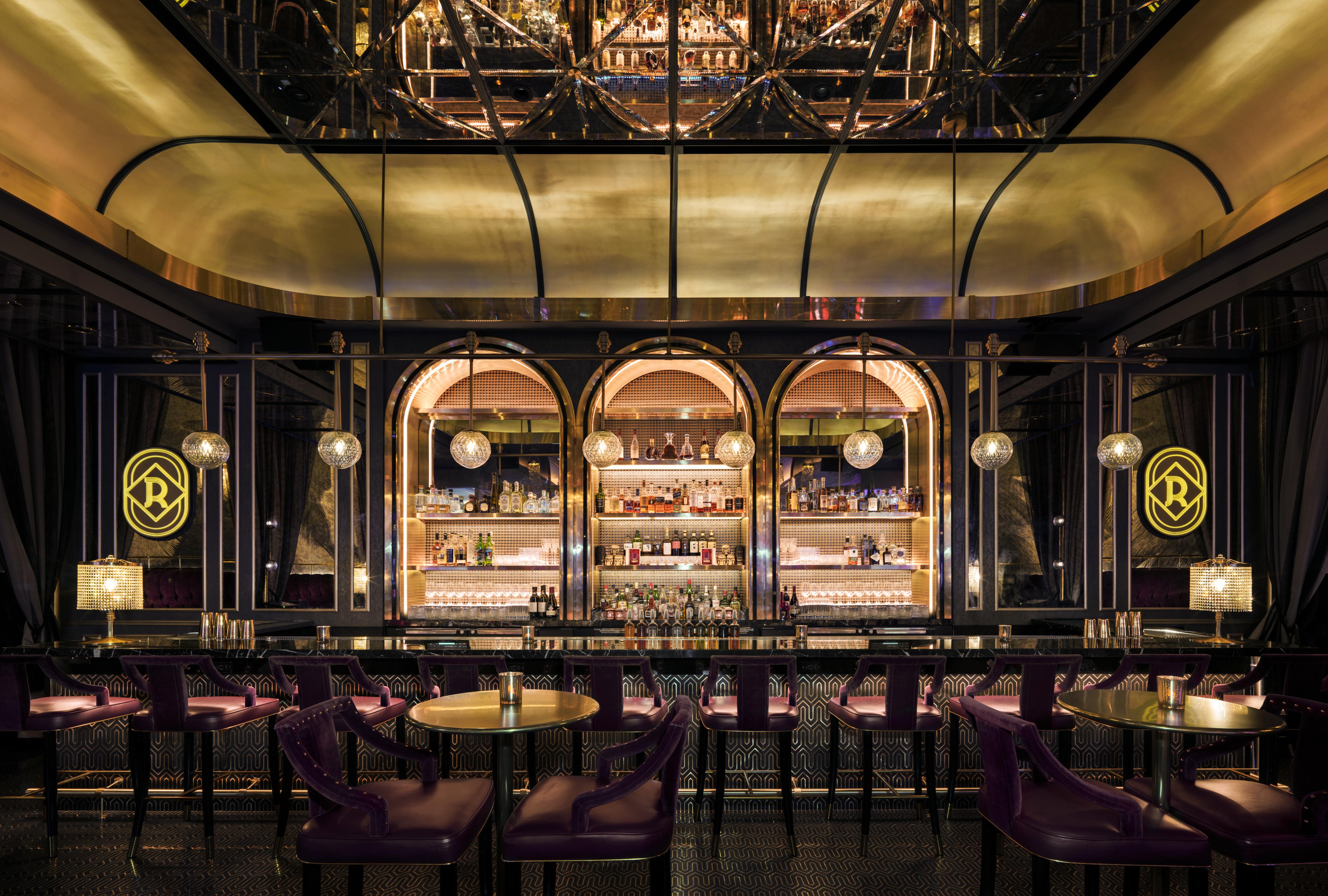 The Palazzo At The Venetian Hotel Las Vegas Exterior photo The photo showcases a stylish and elegant interior of a bar or restaurant. The space features a sleek bar area with an arch design, beautifully illuminated shelving displaying various bottles of spirits. The lighting is warm, creating a welcoming atm