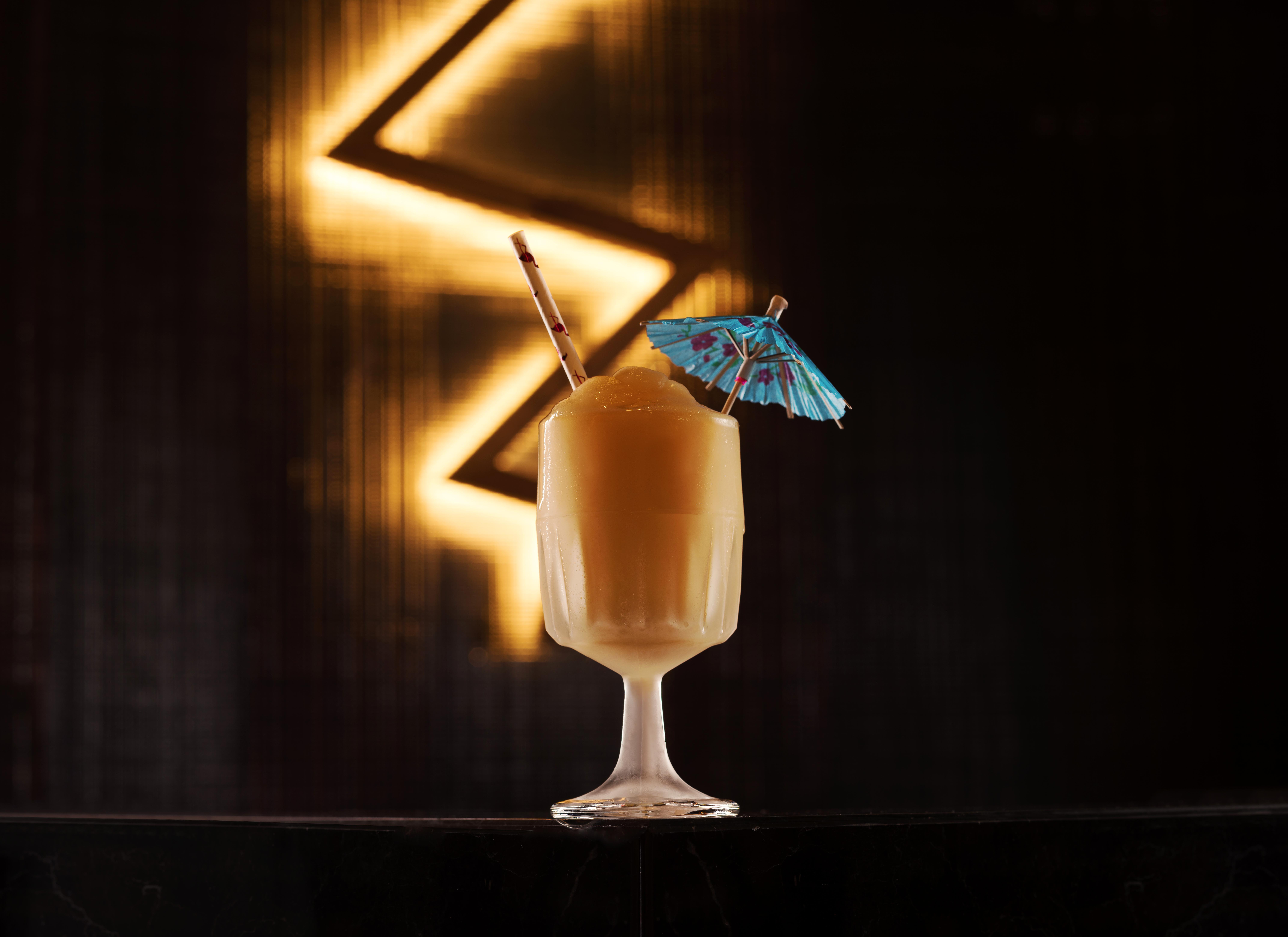 The Palazzo At The Venetian Hotel Las Vegas Exterior photo The photo shows a beautifully presented cocktail in a clear glass. The drink has a creamy, light brown color and is topped with a small blue paper umbrella for decoration. There is also a straw placed in the glass. The background features a dark, ill