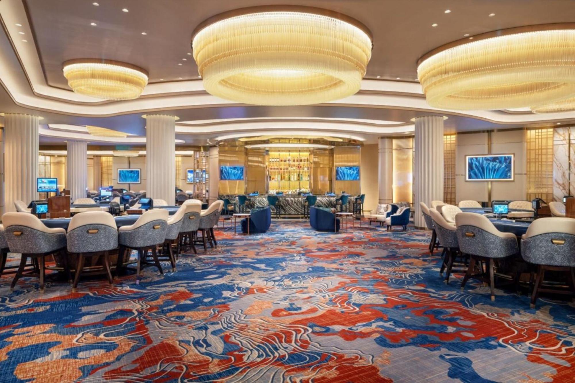 The Palazzo At The Venetian Hotel Las Vegas Exterior photo The photo shows an elegant interior of a casino or gaming area. The space features a variety of seating arrangements, with comfortable chairs and tables for gambling activities. The flooring is adorned with a colorful, abstract carpet design primaril